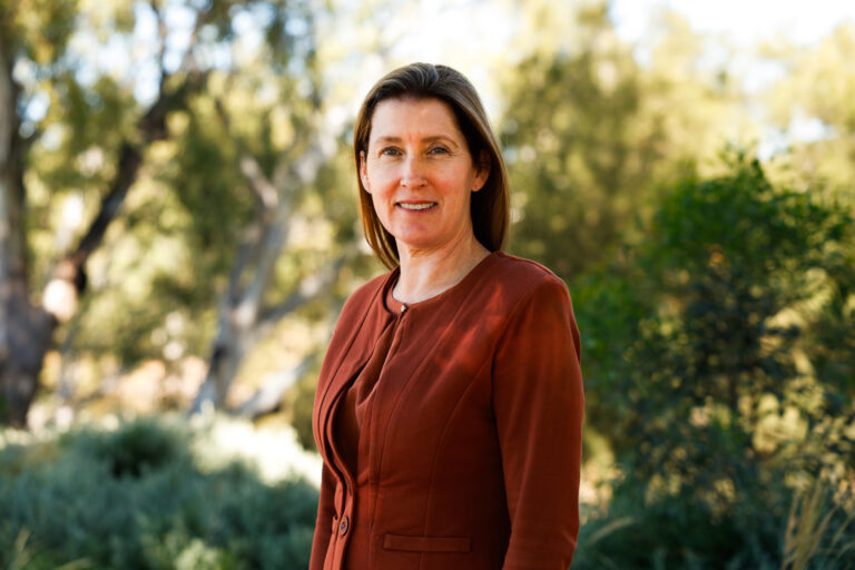 Business woman standing with a natural bush background