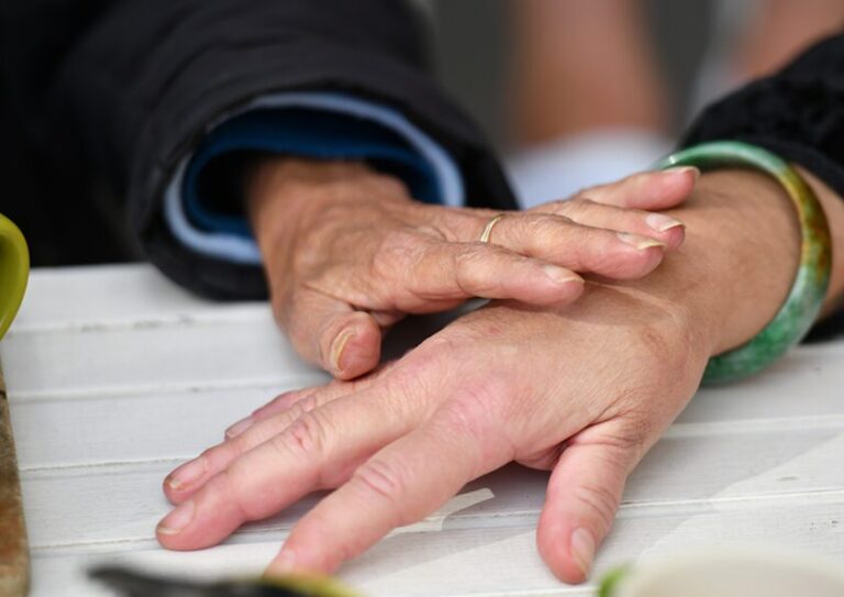 Two women's hands on a table showing support for each other