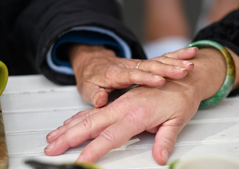 Two women's hands on a table showing support for each other